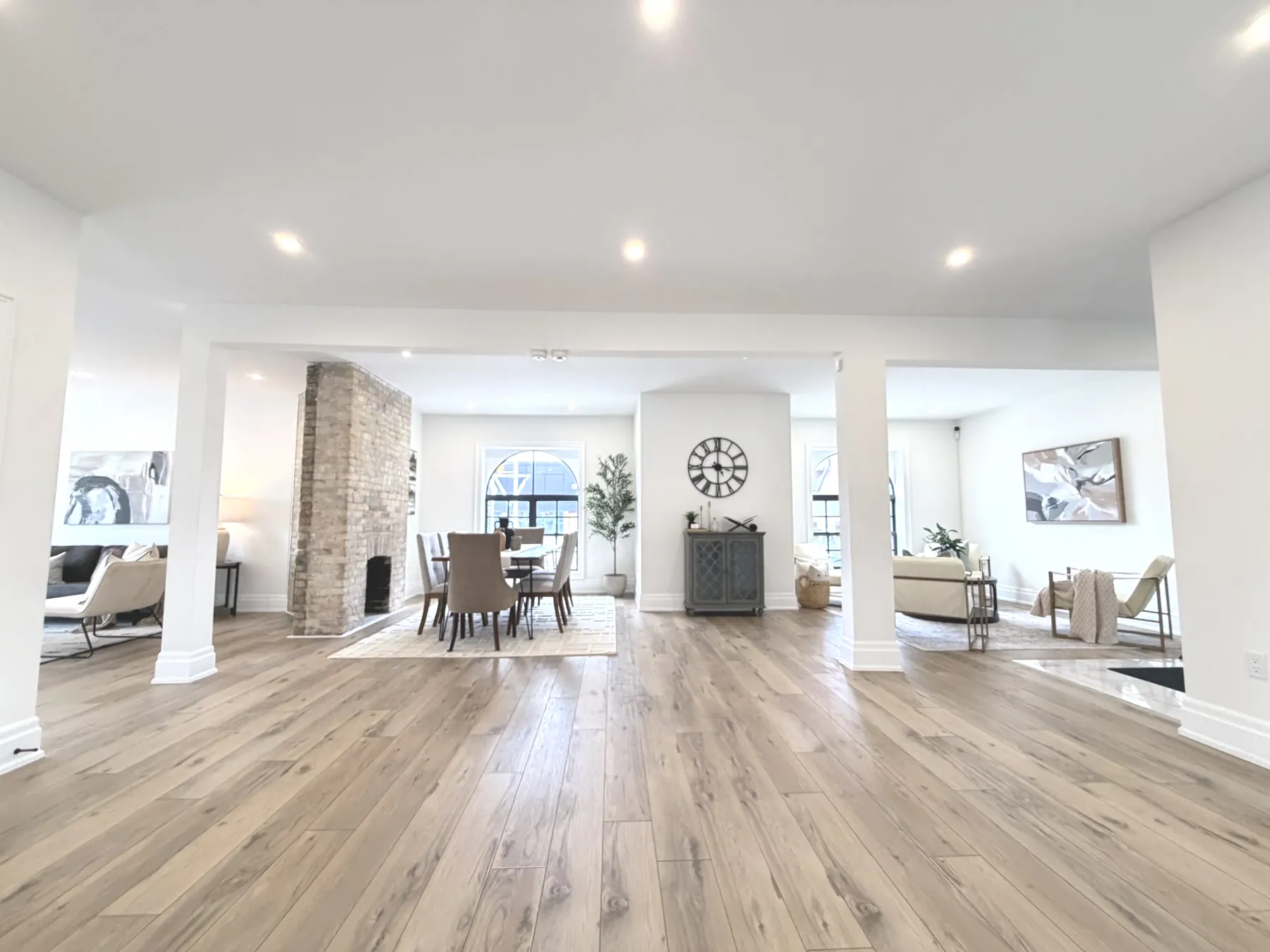Wide view of The Beacon: open studio, white columns, brick fireplace and arched window