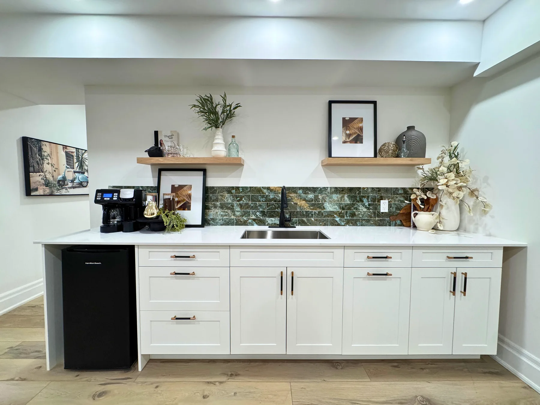 Kitchenette with open shelving, sink and bar fridge